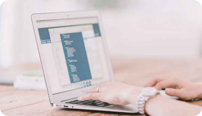 A laptop displaying code on a table, with hands typing, symbolizing YorkPoint Digital's commitment to empowering small businesses and nonprofits through high-quality WordPress website design and SEO solutions.