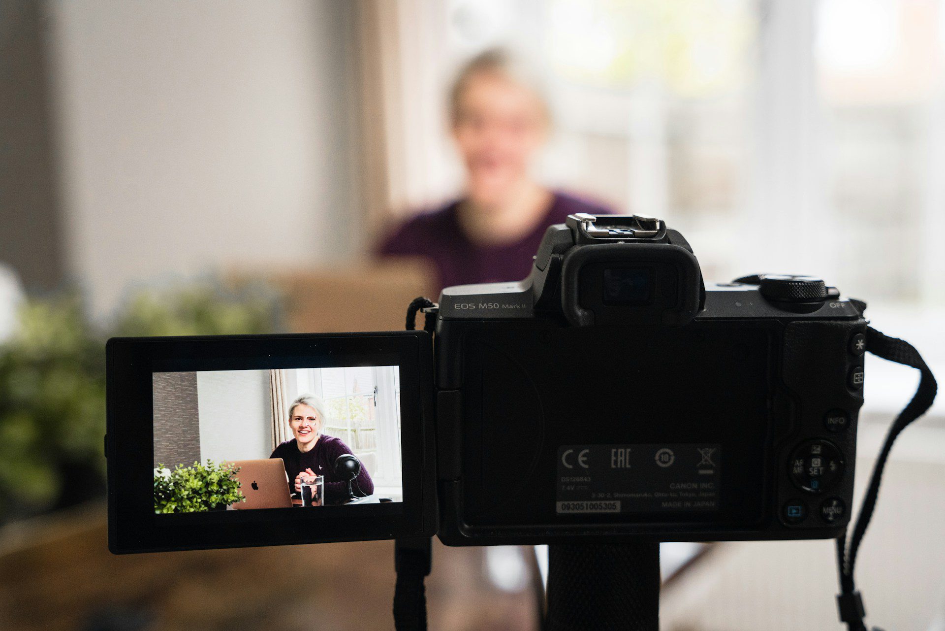 A woman recording a video with a DSLR camera for use on her website, highlighting the benefits of adding video on website pages to boost engagement and trust.